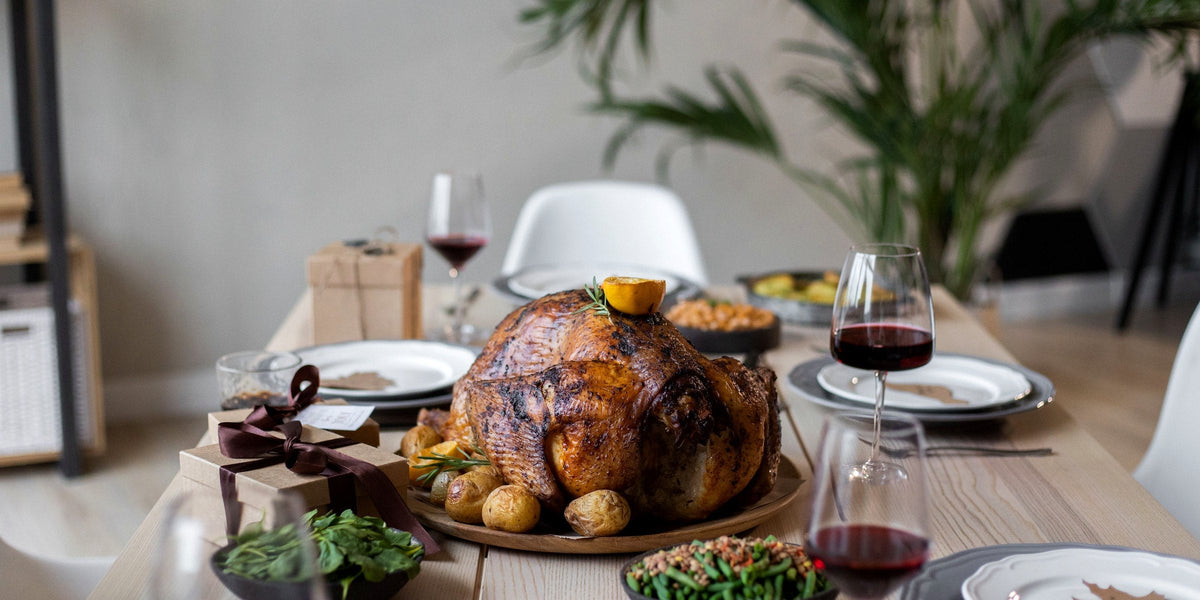 A holiday table with a roasted bird, potatoes, green beans, and all the classic sides